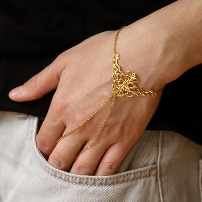 delicate boho hand chain bracelet ring with intricate filigree detail worn on a hand, featuring fine chains and a feminine, elegant design