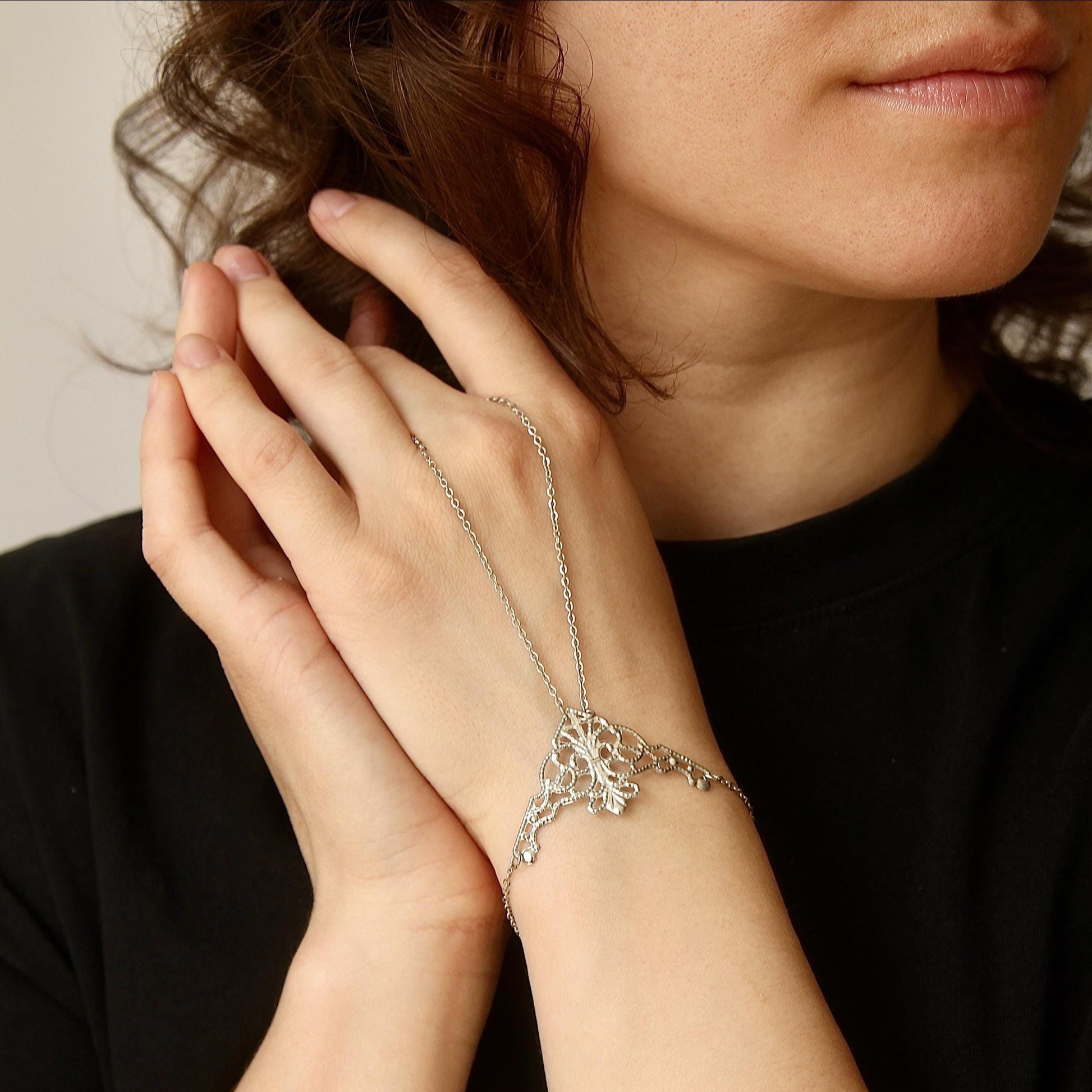 delicate boho hand chain bracelet ring with intricate filigree detail worn on a hand, featuring fine chains and a feminine, elegant design