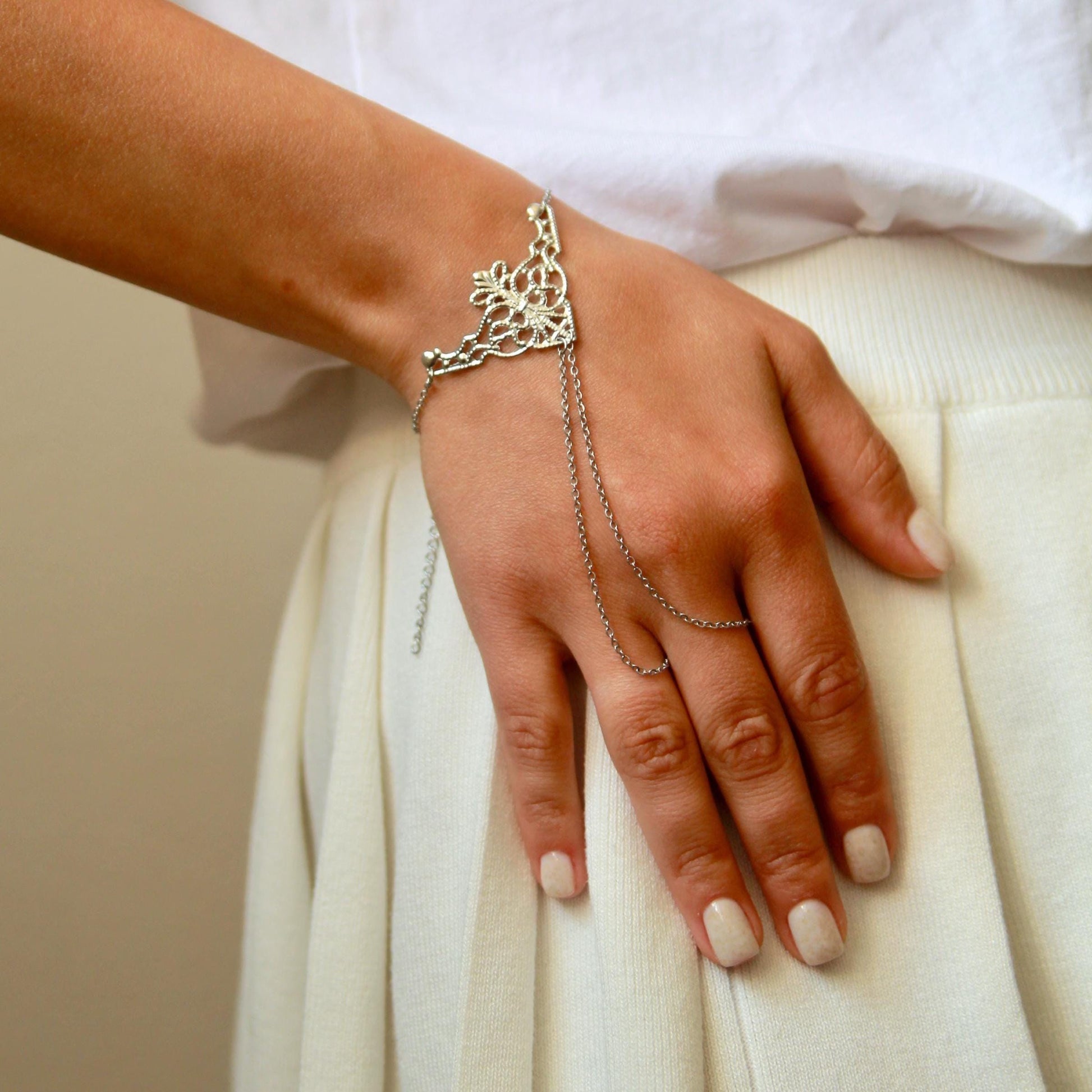 delicate boho hand chain bracelet ring with intricate filigree detail worn on a hand, featuring fine chains and a feminine, elegant design