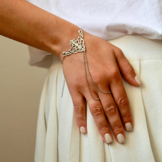 delicate boho hand chain bracelet ring with intricate filigree detail worn on a hand, featuring fine chains and a feminine, elegant design