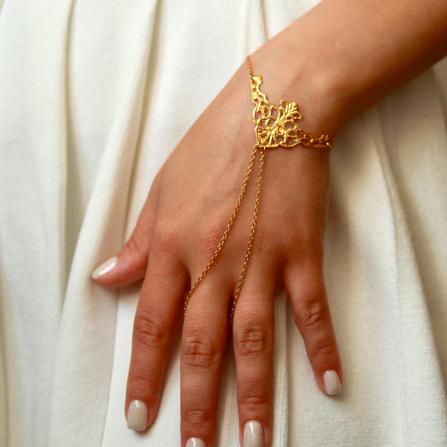 delicate boho hand chain bracelet ring with intricate filigree detail worn on a hand, featuring fine chains and a feminine, elegant design